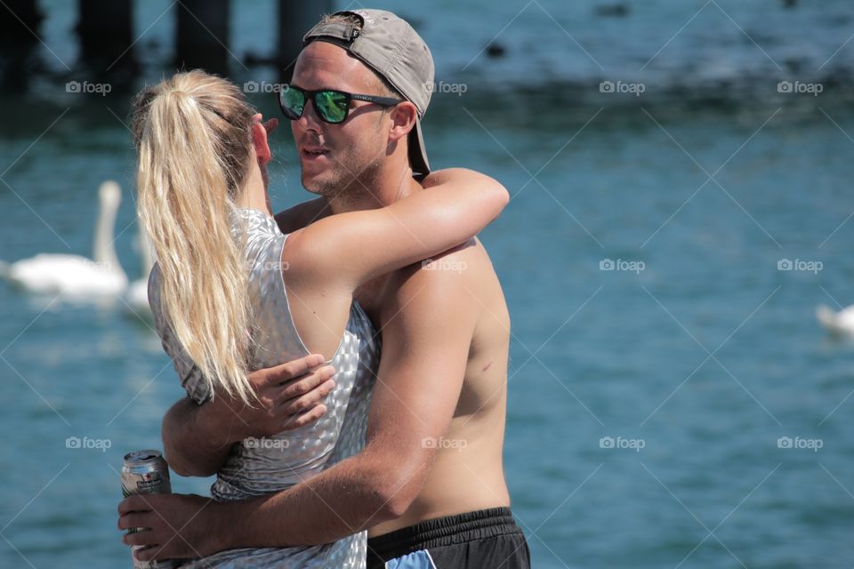Young Couple Cuddling. Young couple cuddling on lake shore