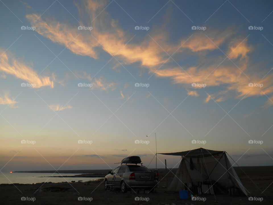 people resting on a sunset sea shore summer time wild travel