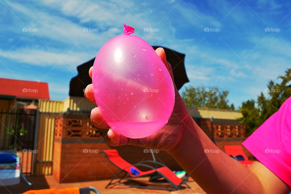 Child holding water balloon. Child about to throw a pink water balloon