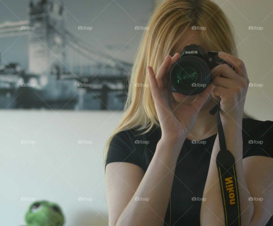 Blonde woman taking photo with Nikon Camera