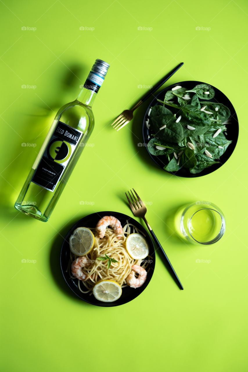 Flat lay of a bottle of Ecco Domani wine with dinner plates 