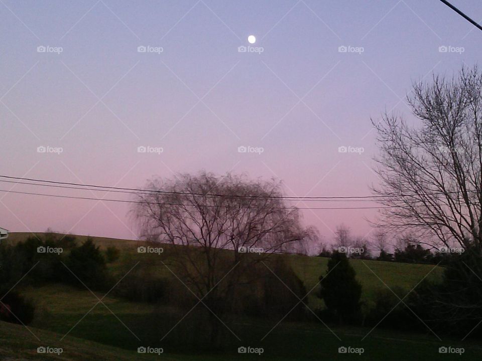 Moon over hill at dusk