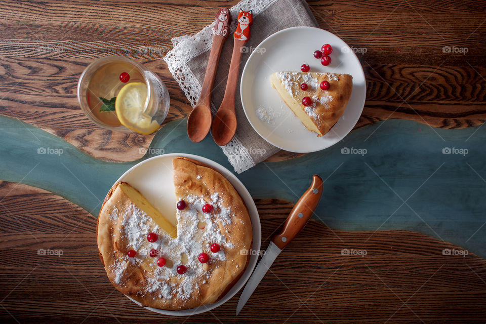 Cheesecake with cranberries and sugar on wooden background