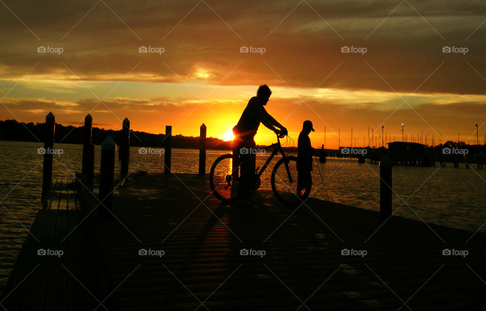 Cyclist . Boy bicycling in the sunset 