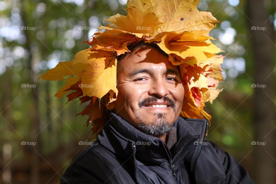 Happy middle-aged man in a leaves crown