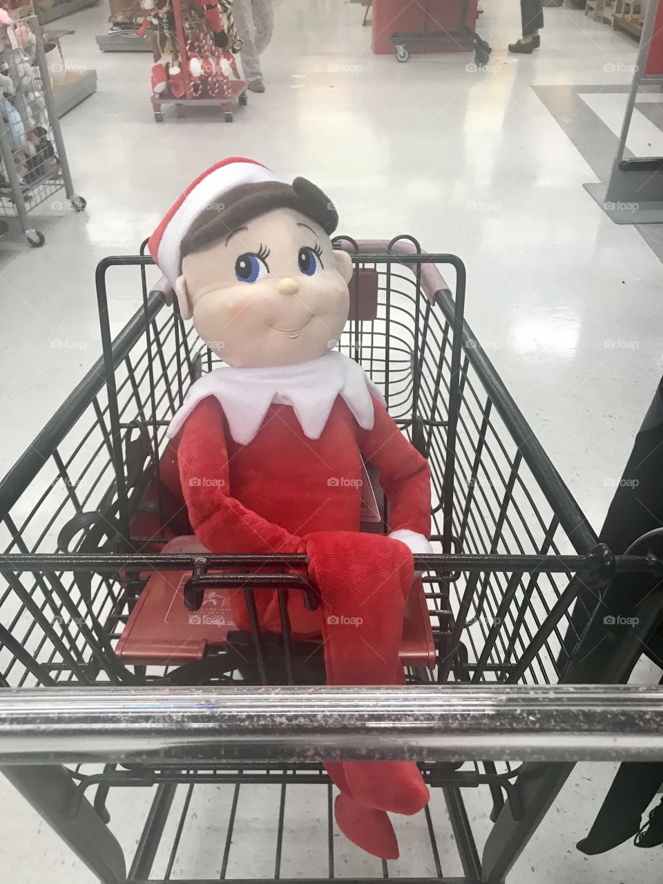 A mischievous Elf on the shelf doll sitting in a shopping cart at the department store. USA, America 
