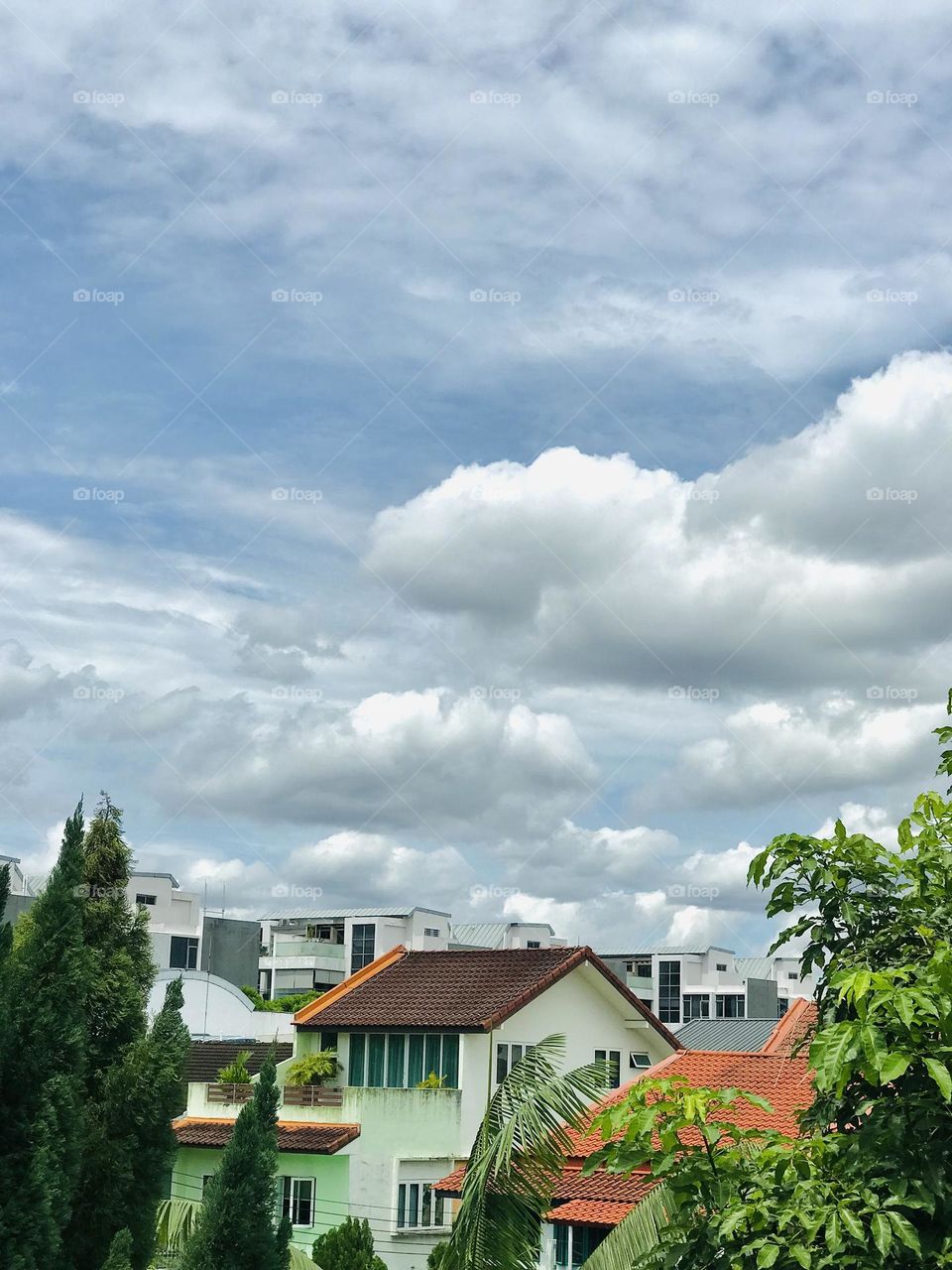 Beautiful silver clouds in the sky and beautiful ancient individual houses along with greenery below the clouds looks beautiful 😍