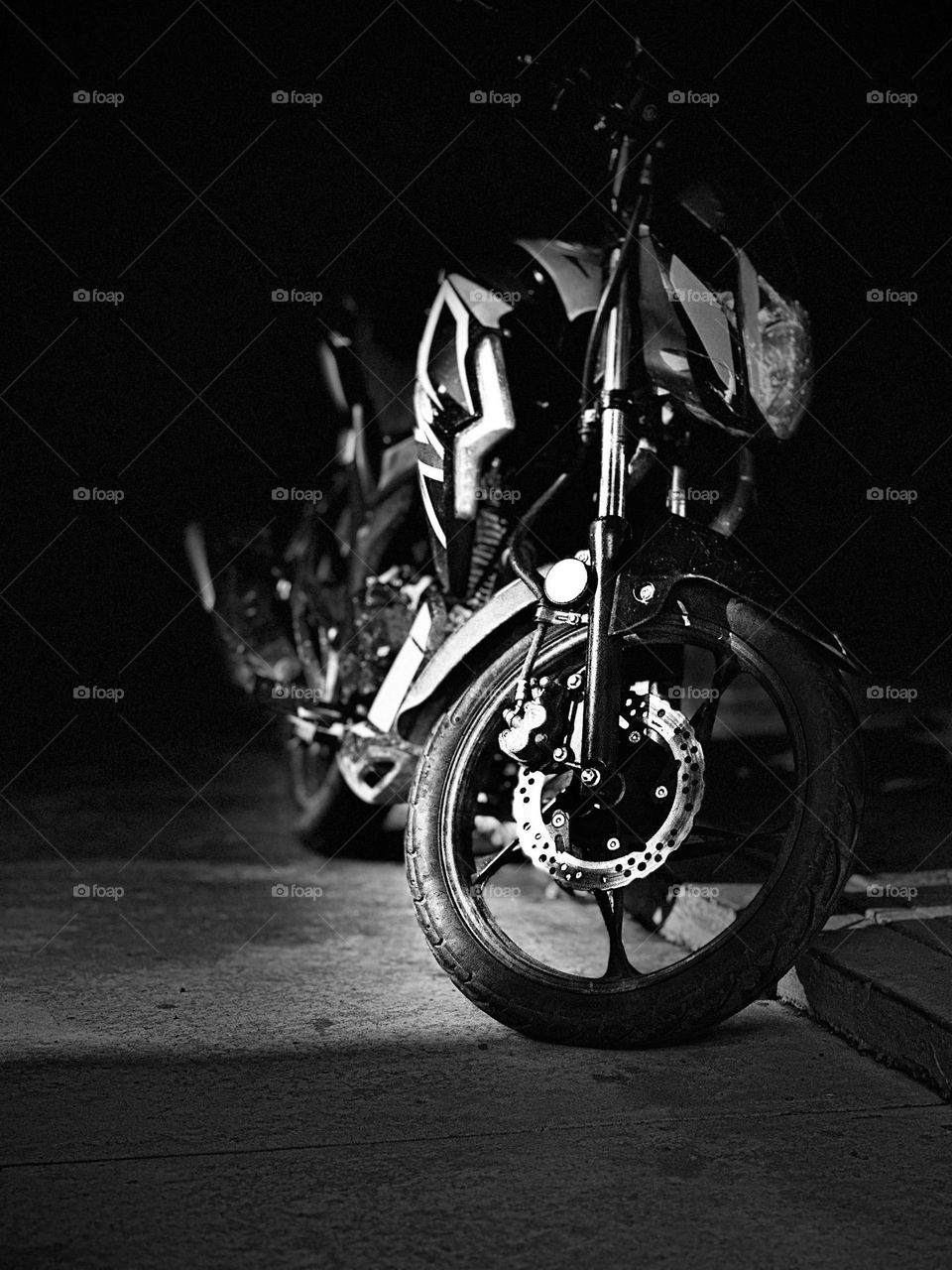 Sport motorcycle parked at the midnight with the darkness in the background in monochrome style.