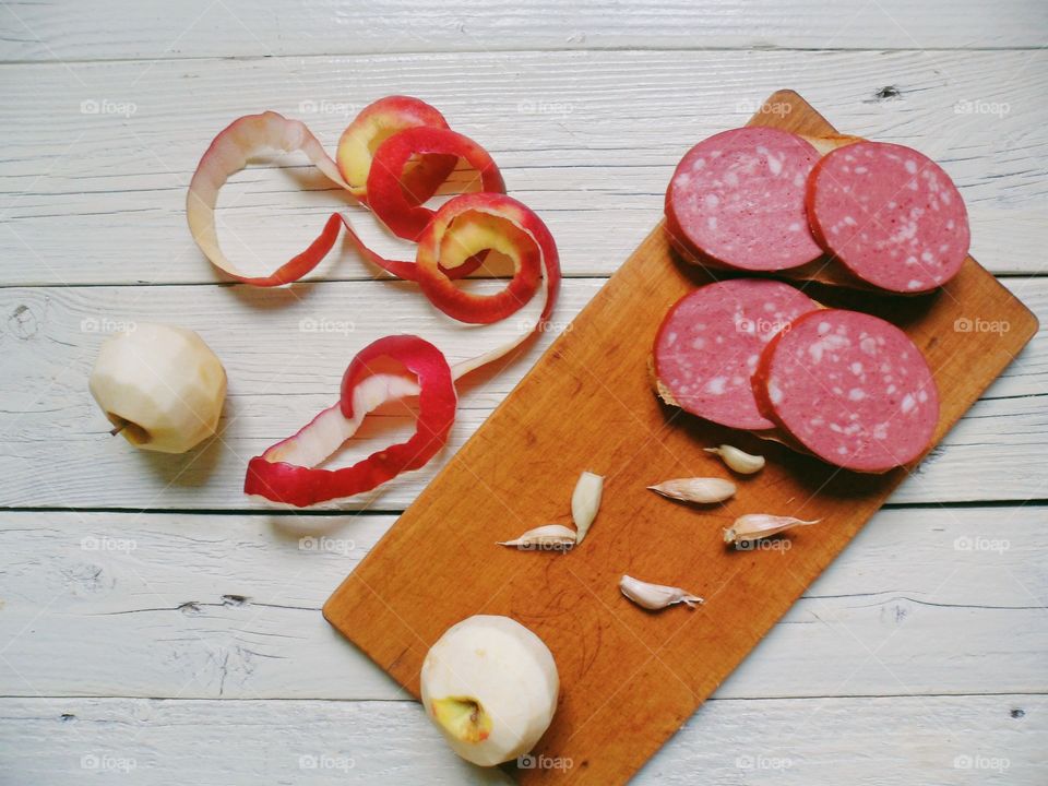 sandwiches with sausage, garlic, peeled apple on a cutting board