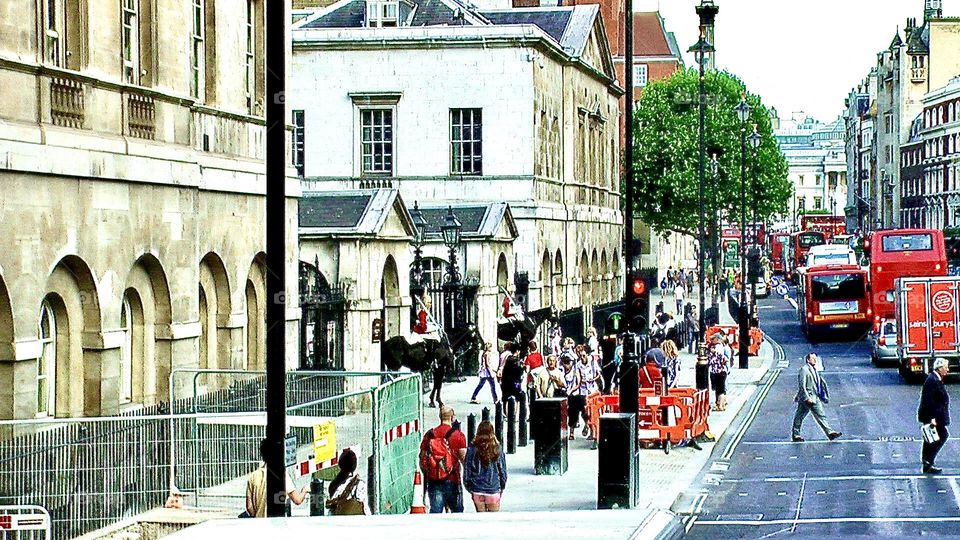 Busy sidewalk and street in London full of vehicles and pedestrians on their way to daily routine 
