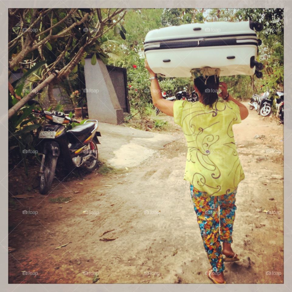 Only in indo . The lovely lady carrying my bag up 100 stairs to the road. Bali life is different but it works 