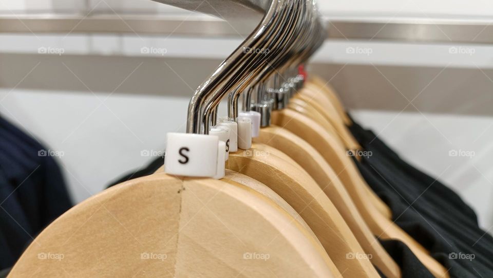 Close up view of hanging clothes arranged on a display rack small size.