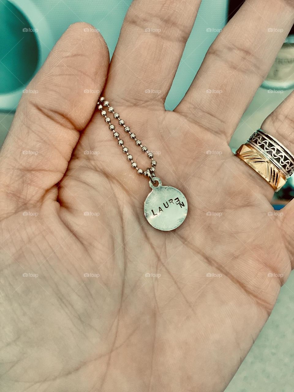 Woman holds necklace in hand, name necklace of woman, jewelry with names on it, Lauren necklace, simple jewelry 