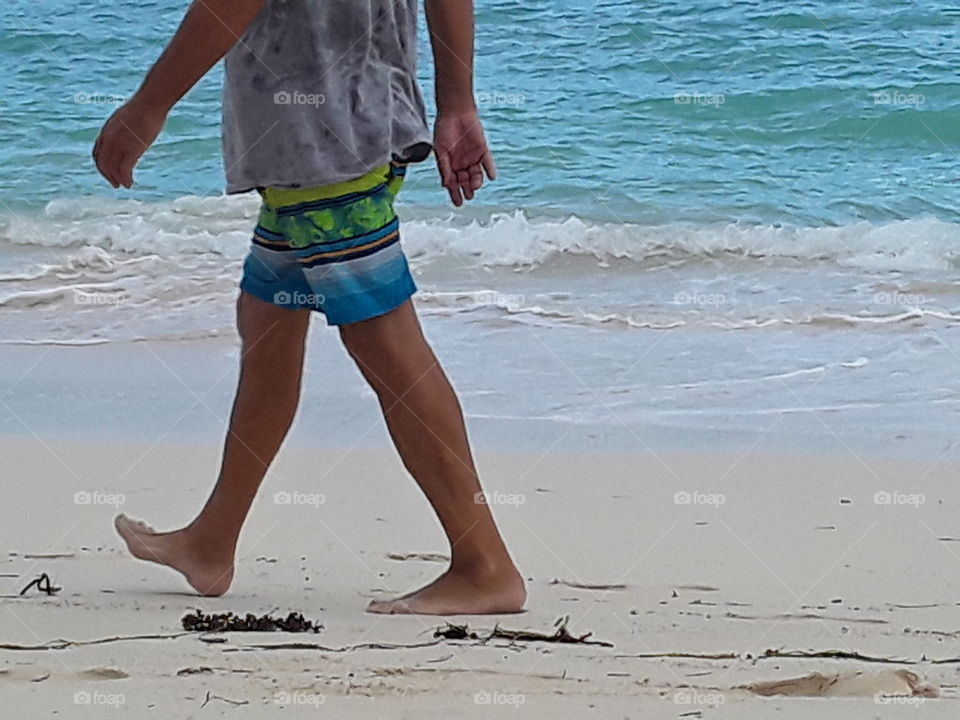 a man walks along the beach