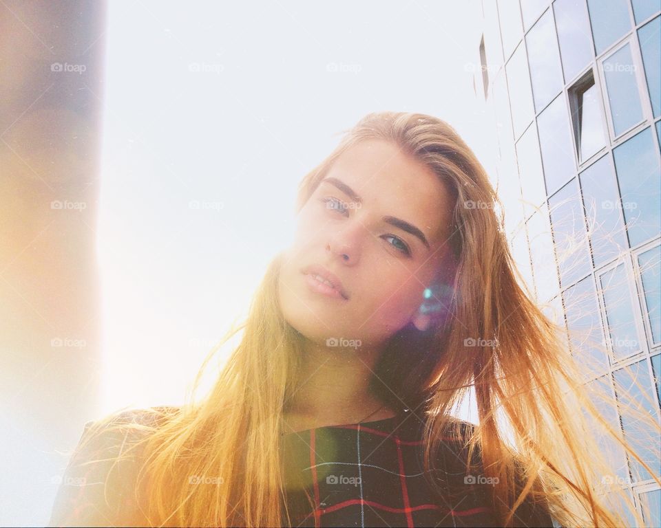 Woman in front of a modern office building with sunlight