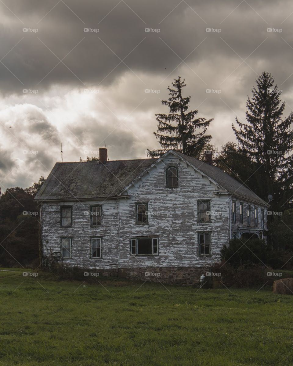 Old abandoned house backdropped by some moody clouds