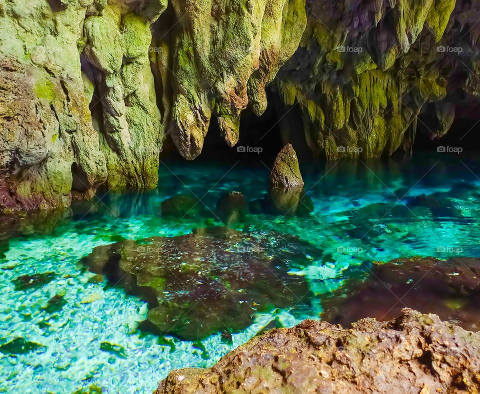 The enchantment of a mystical stone in the blue water in Hawang Cave