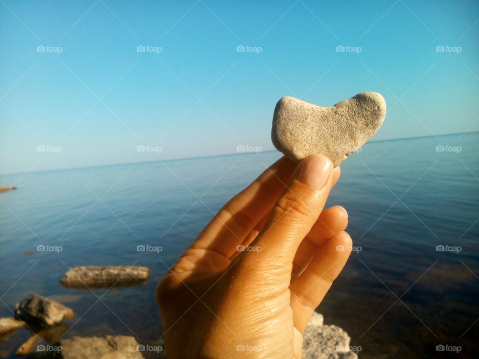 hand and sea stone heart