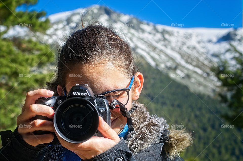 Woman photographing in front of mountain