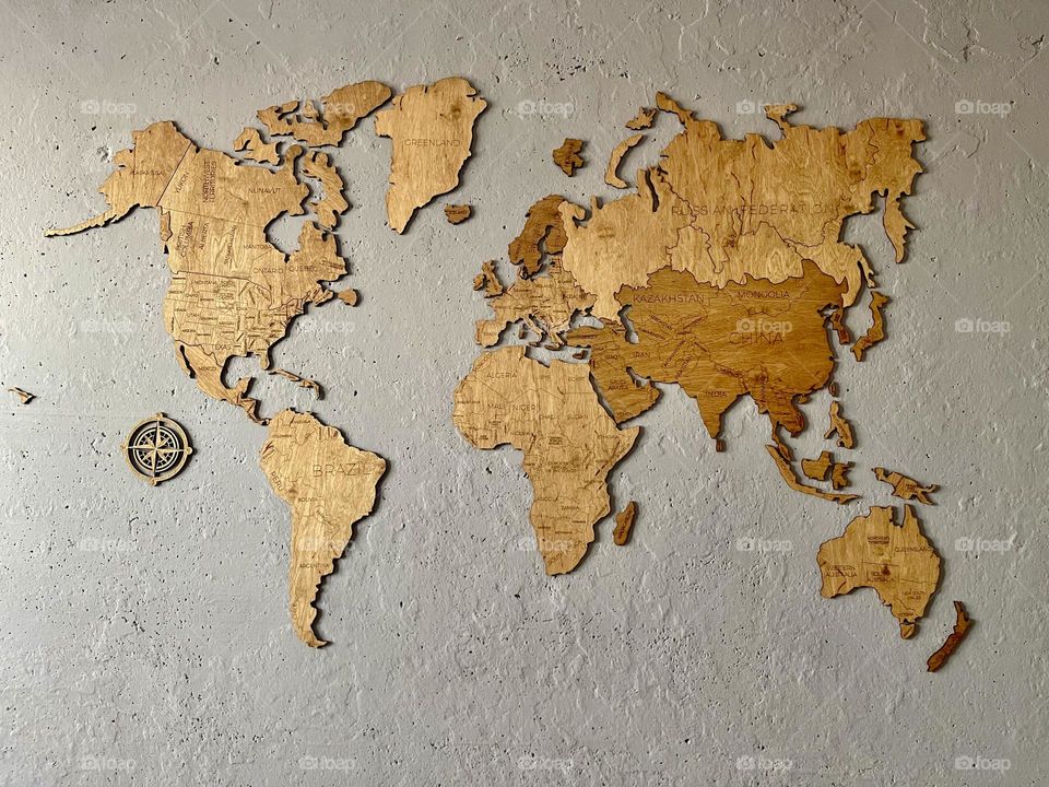 Wooden world map on the grey wall