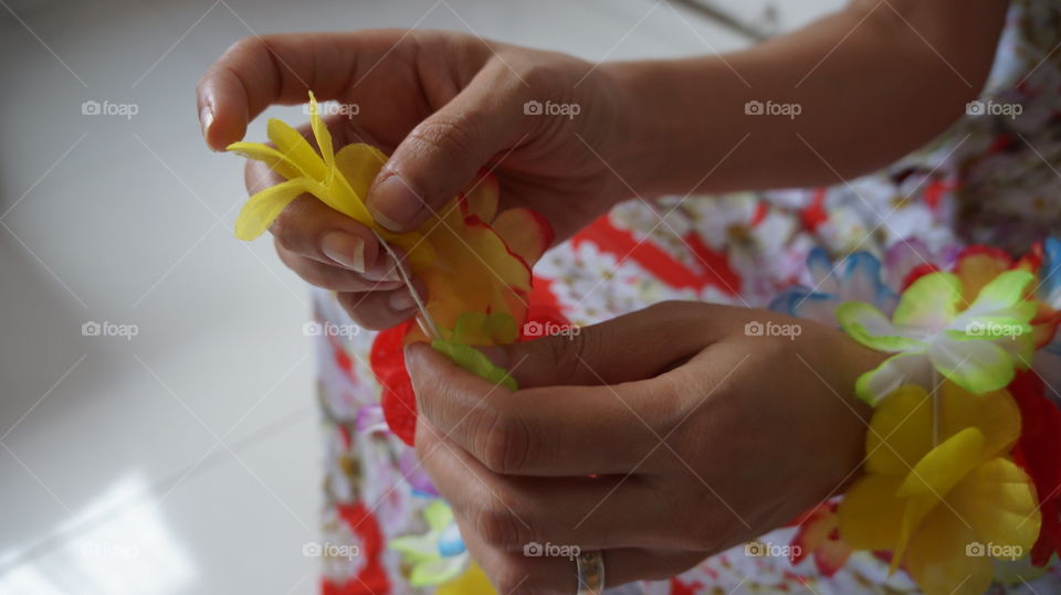 Girl making necklace with hawaiian flowers