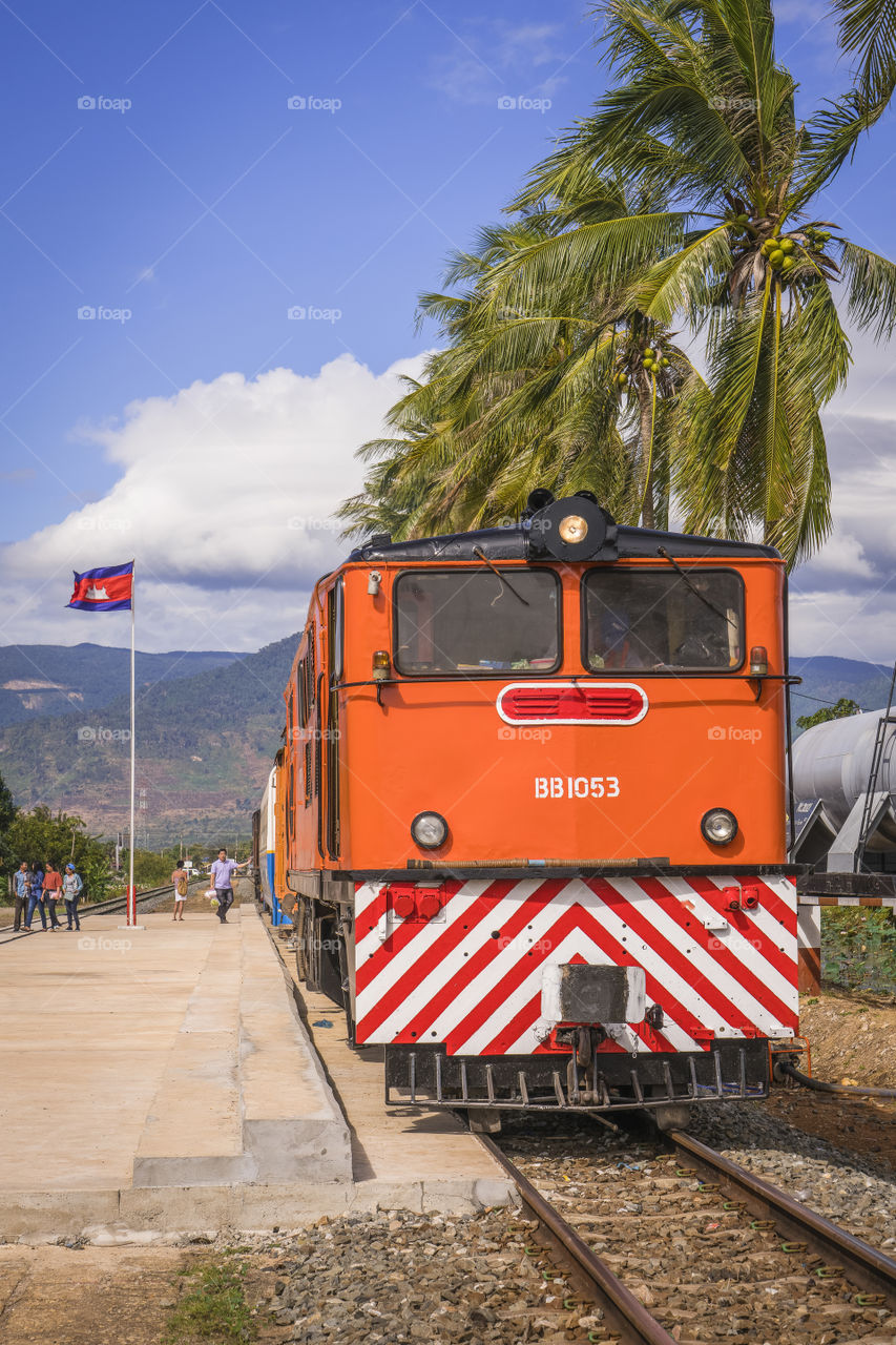 KOMPOT/CAMBODIA - February 04, 2017: Passenger cabin train arrives at Kampot train station with a beautiful blue sky and coconut tree stand in line