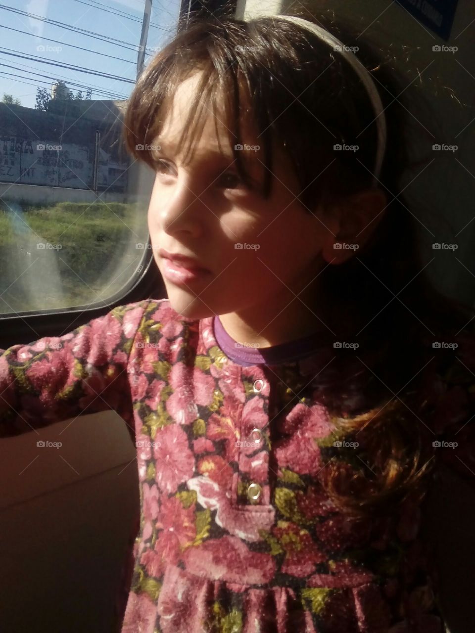 imagen de una niña pequeña viajando en tren y contemplando el paisaje extasiada. Buenos Aires.  Argentina.