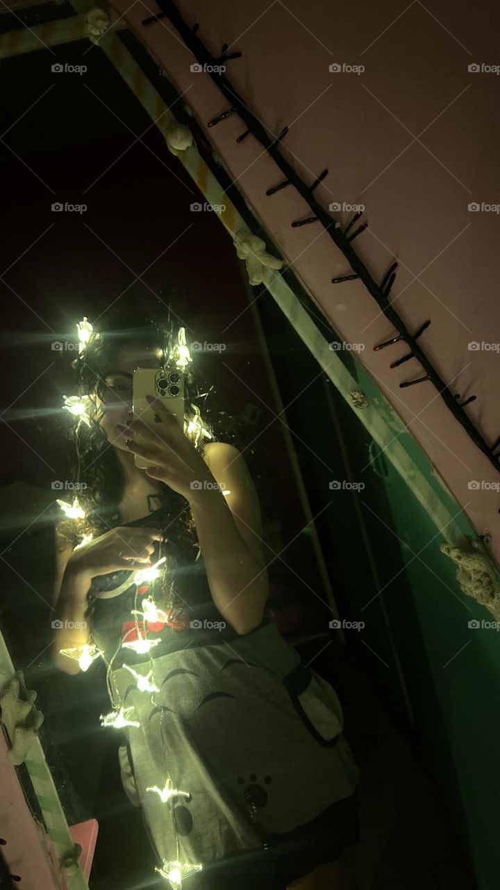 Curly-haired girl in a dark room with strands of light