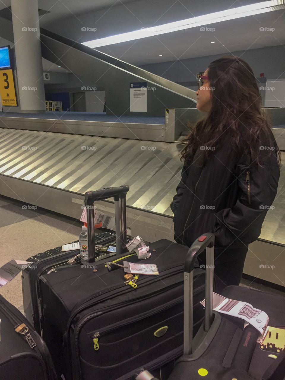 A girl waiting for a bag in the baggage claim