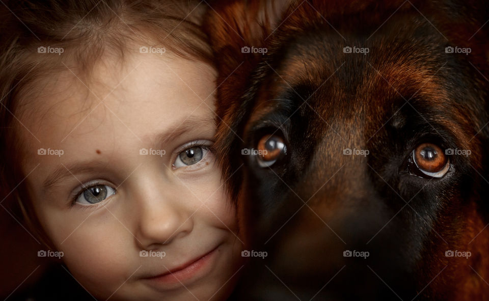 Little girl and German shepherd close up portrait with accent on the eyes 