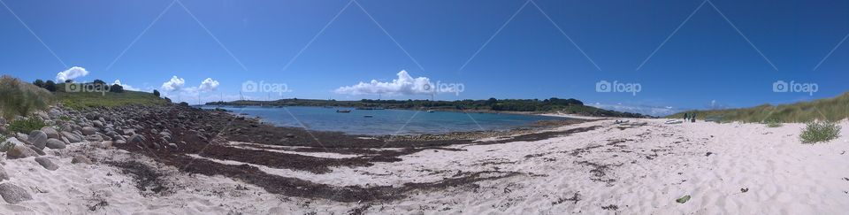 Panoramic beach view of the sand bar on St Agnes, Scilly isles.