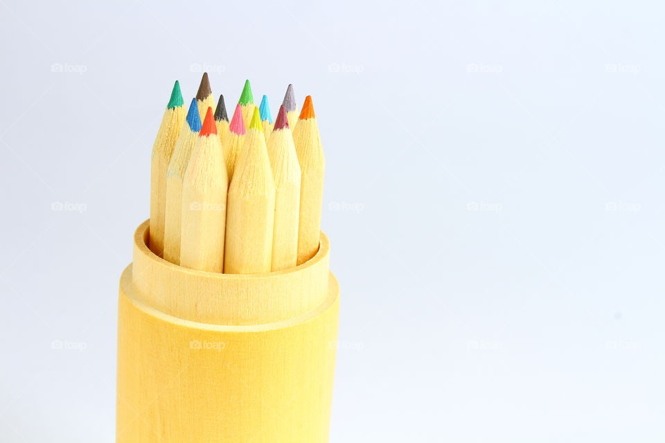 Group of color crayons in a wooden cylinder isolated macro