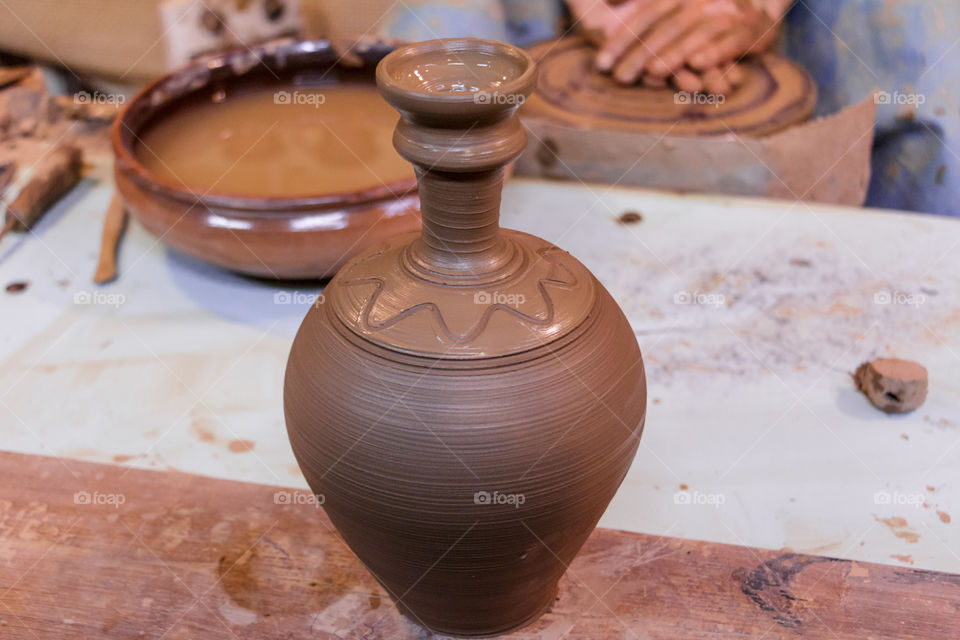 Learning pottery - man making a pot of clay