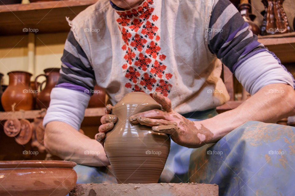 Learning pottery - man making a pot of clay