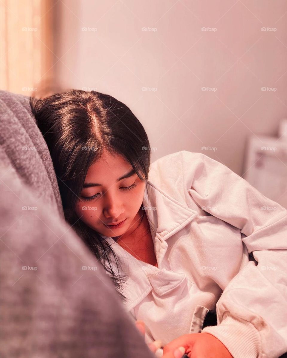 Close-up view of beautiful young woman lying on a warm mattress in pastel colors