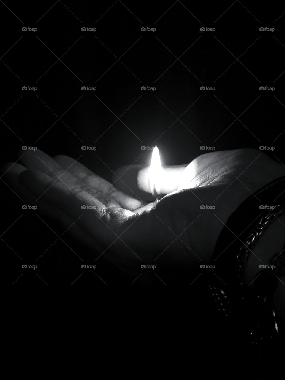 Woman's hand holding a small flame of fire