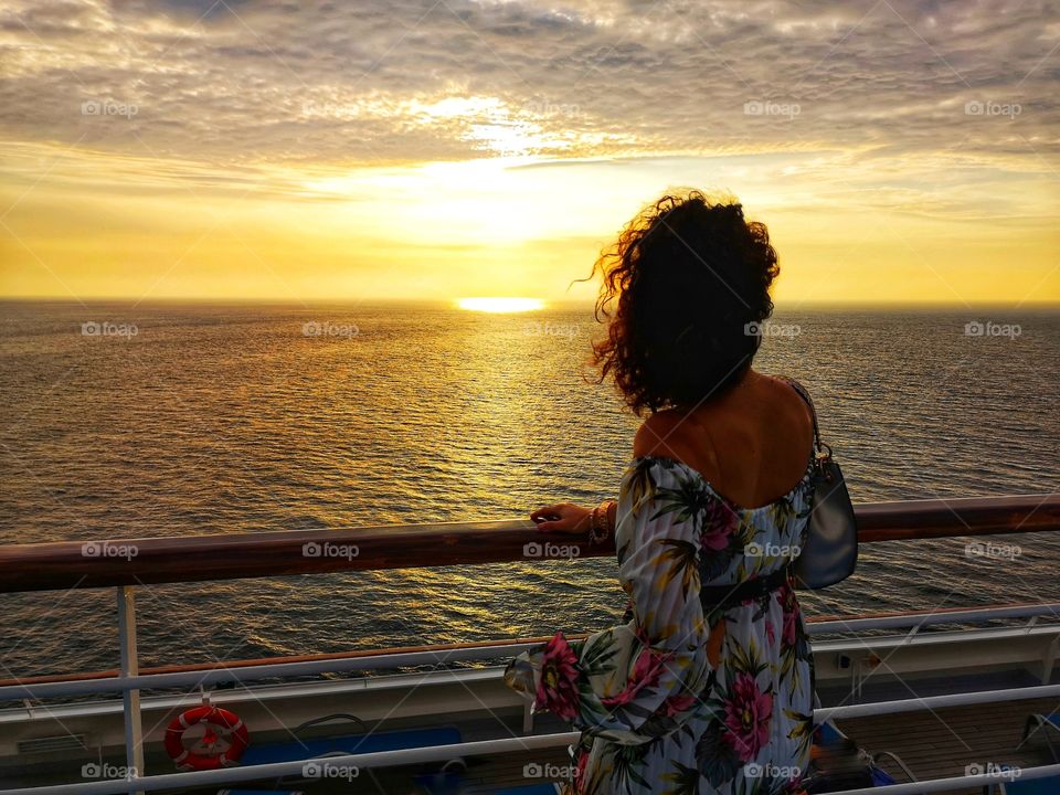 Woman's back looks at the sunset