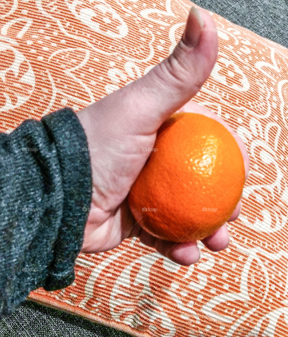 Elevated view of hand holding orange