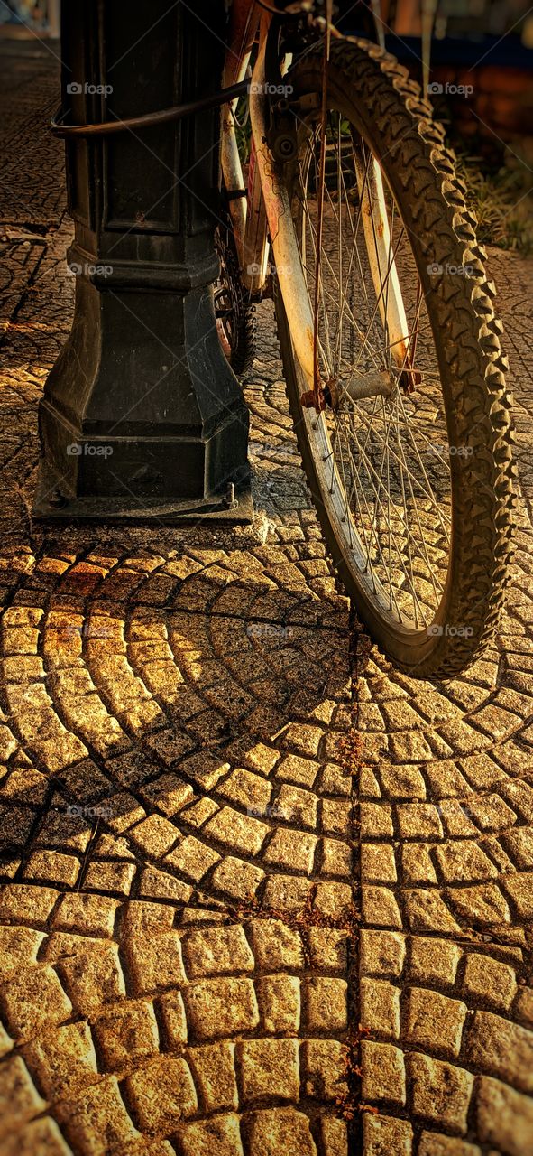 Bicycle on the post on the sidewalk
