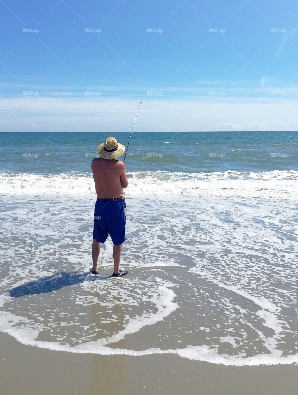 Man surf fishing at the beach. 