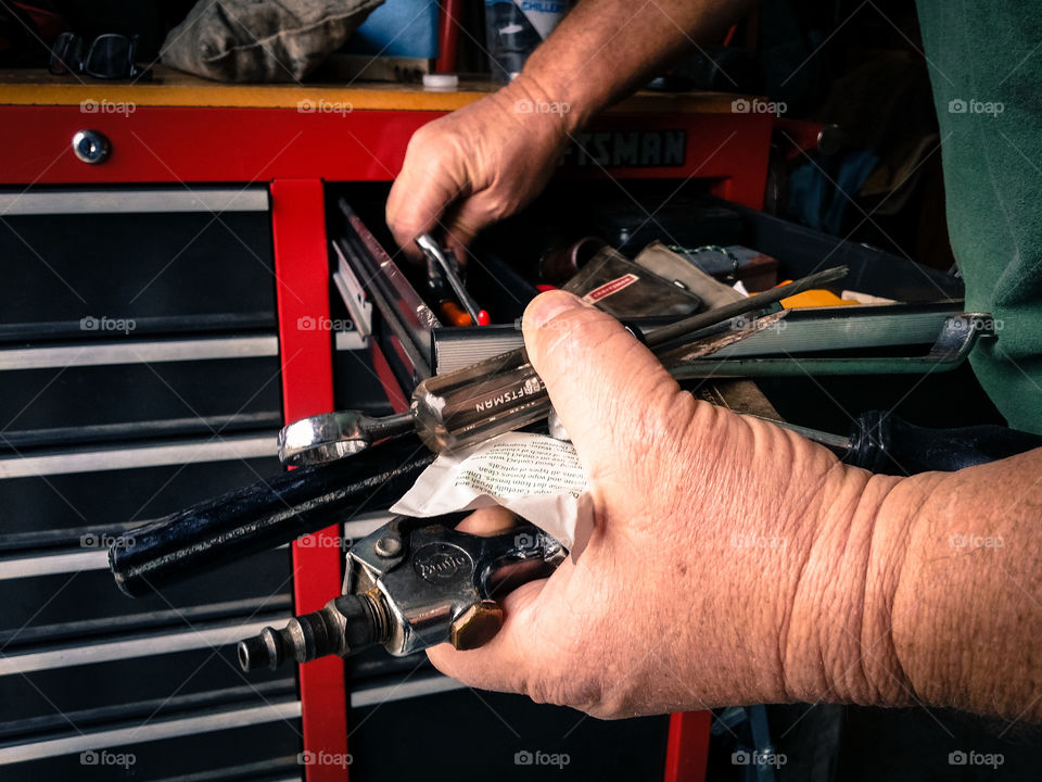 Close-up of men searching tool in drawer