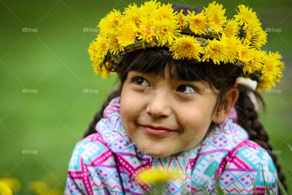 Cute little girl with an dandelion wreath