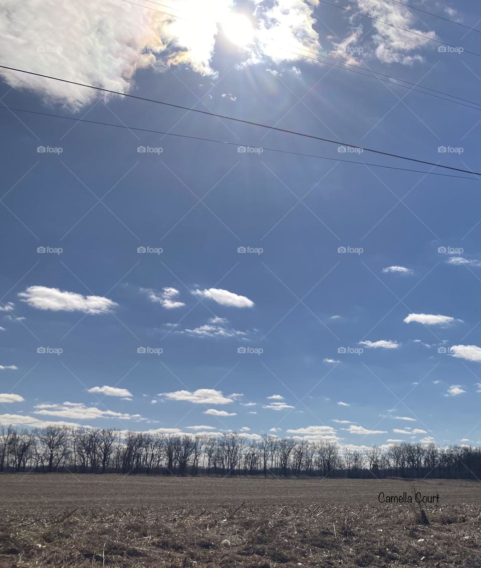 The sun casting colors on an open field