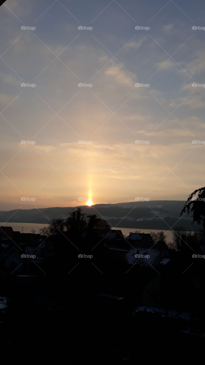 Sunrise in January with a golden arrow at lake constance.