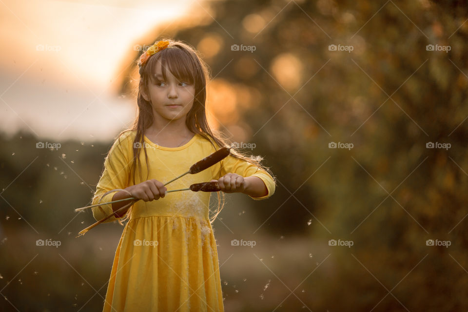 Little girl in yellow dress outdoor portrait at sunset 