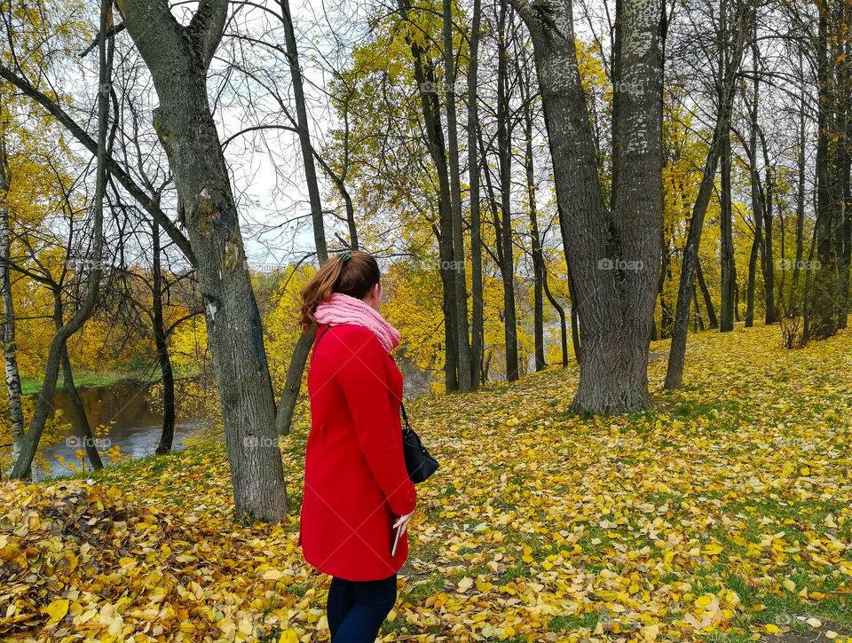 female figure in the red coat in the autumn park