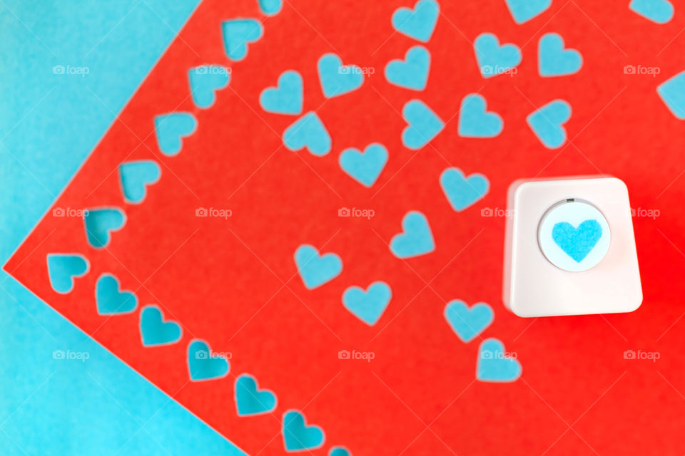 Heart shaped hole puncher on colorful background