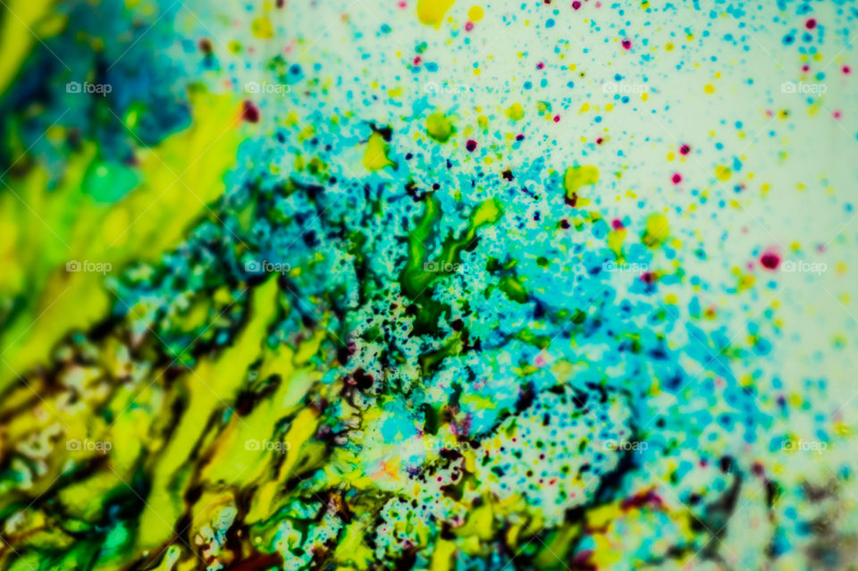 The ink to refill the printer cartridge was spilled onto the white washbasin and the paints blended into abstract drips and patterns.