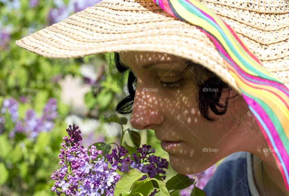 Woman smells lilac flowers