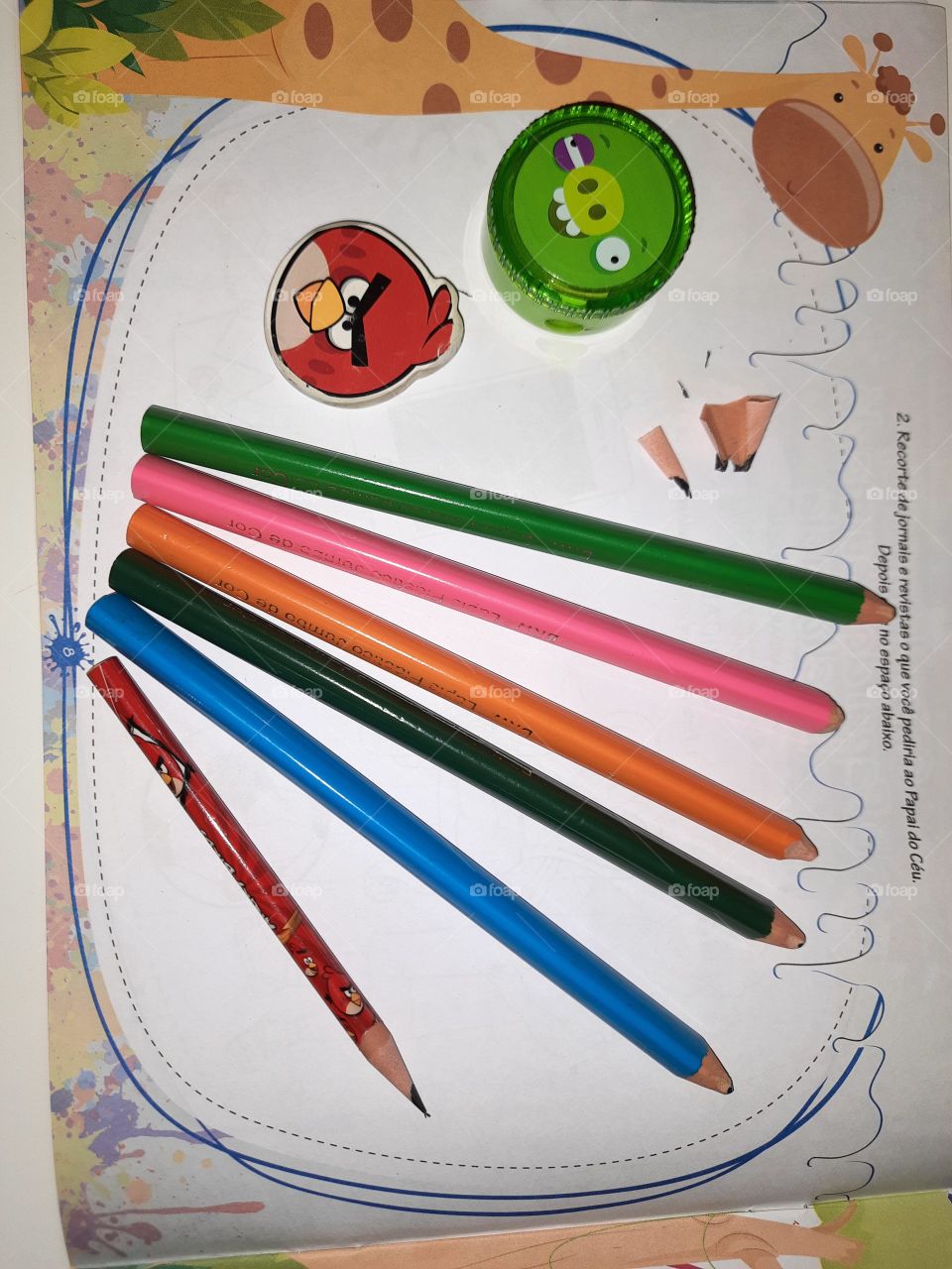 colored pencil eraser and pencil sharpener on top of the book